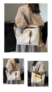 Detail of lychee textured tote bag with contrast trim and woven tassel accessory