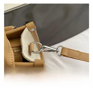 Detail of premium silver metal hooks and brown leather trim on canvas tote bag