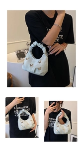Détail du sac hobo en daim vert clair avec papillons dorés et poignée à volants chic