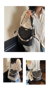 Close-up of black litchi pattern bucket bag with polka dot silk scarf and gold chain handle