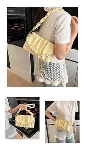 Détail du sac nuage plissé jaune clair avec texture brillante et chaîne à grosses perles