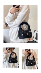 Détail du sac en velours noir avec papillons dorés et une poignée plissée style chouchou