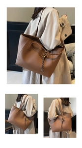 Detailed view of brown litchi pattern leather tote with woven rope and metal accents