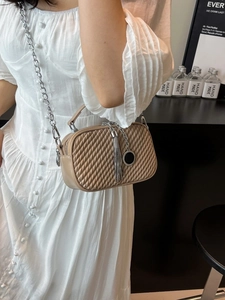 Sac bandoulière beige matelassé chic avec chaîne argentée et détail de pompon