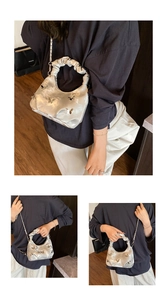 Détail d'un sac à main argenté plissé avec breloques papillon et bandoulière chaîne