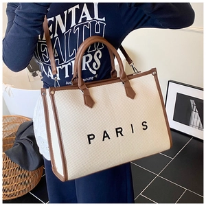 Vista dettagliata della grande borsa tote intrecciata crema con finiture in pelle
