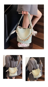 Detail of mint green lychee pattern bucket bag with chain scarf and leather strap