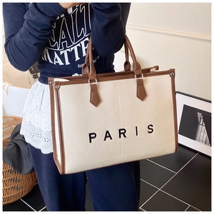 Dettaglio della borsa tote in tela con ricamo Paris e manici in pelle marrone