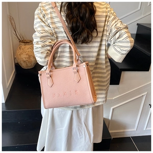 Borsa tote rosa con goffratura Paris indossata da una modella su sfondo minimalista