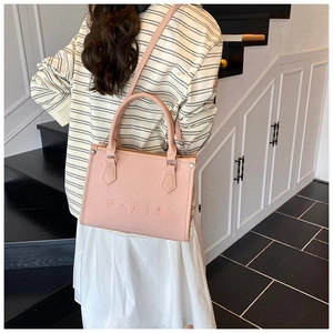 Dettaglio della borsa tote rosa con trama intrecciata e logo PARIS in rilievo sopra