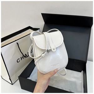 Close-up of a mini white glossy leather crossbody bag with elegant gold foil lettering