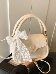 Elegant beige handbag with lace bow detail featuring top handle and gold hardware accents