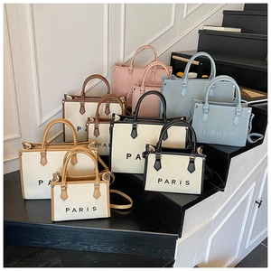 Collection of PARIS woven canvas tote bags in assorted colors and sizes on steps