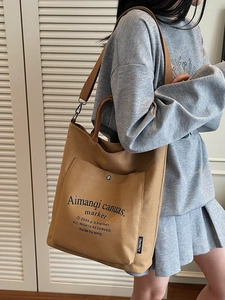 Minimalist canvas tote bag in caramel brown featuring a spacious interior and metal snap pocket