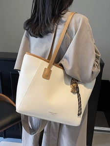 Large beige PU leather tote bag with brown straps and star pendant shown on model