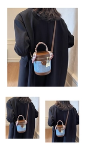 Detail of denim bucket bag with leather trim and houndstooth scarf on the top handle