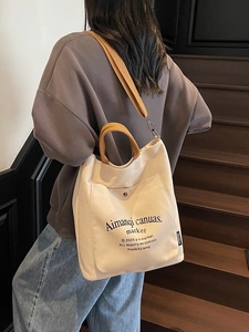 Minimalist canvas tote bag with brown straps and large capacity for daily commuting