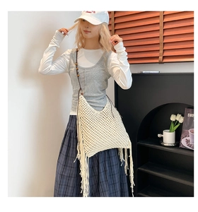Détail d'un sac fourre-tout au crochet beige évidé avec de longues franges