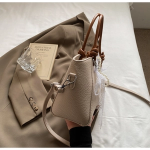 Détail du sac cabas blanc cassé avec poignées nouées, perles et dentelle chic