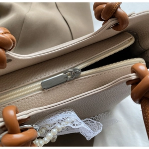 Détail du sac cabas en cuir grainé avec fermeture éclair argentée et poignée marron