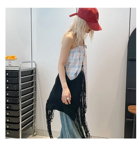 Gros plan détaillé du sac à bandoulière tissé noir avec de longues franges à glands