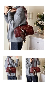 Detail der dunkelroten Vintage-Tasche mit zwei Vordertaschen und Bärenanhänger