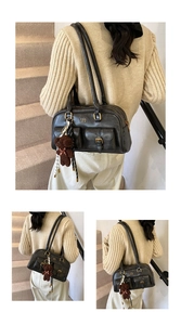 Details einer schwarzen Schultertasche mit Vordertaschen und braunem Bärenanhänger