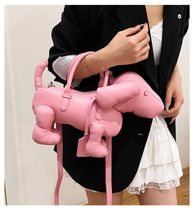 Rosa Umhängetasche in Dackelform aus feinem Leder, getragen von einem Modell im Anzug