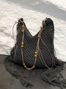 Sac fourre-tout noir au crochet bohème avec longues franges et perles en bois sur roche