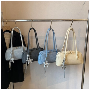Sacs Boston minimalistes en gris, bleu et beige suspendus à des crochets avec charms étoile