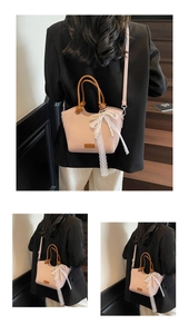Gros plan d'un sac à main rose en cuir grainé avec nœud en dentelle et chaîne perle