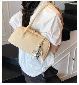 Détail du sac Boston crème à texture tissée avec double bandoulière et étoile argentée