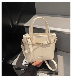 Detail of off-white pleated leather bag with gold buckle and embossed branding on bottom