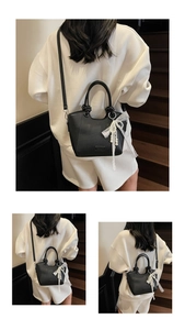 Détail du sac cabas en cuir noir avec nœud en dentelle et breloque en perles