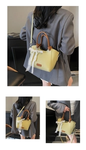 Détail d'un grand sac cabas vert clair avec poignées tressées et nœud en dentelle