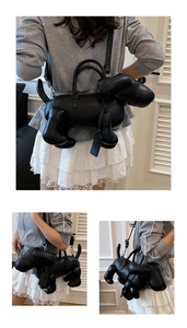 Details der kreativen schwarzen Handtasche in Welpenform aus Leder mit abnehmbarem Gurt