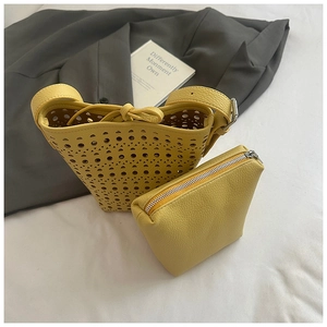 Détail du motif ajouré et de la pochette intérieure jaune à texture grainée de litchi