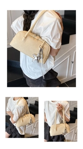 Détails du sac Boston en cuir texturé beige crème avec un pendentif en forme d'étoile argenté
