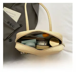 Vue intérieure du sac tressé beige montrant l'espace de rangement des cosmétiques