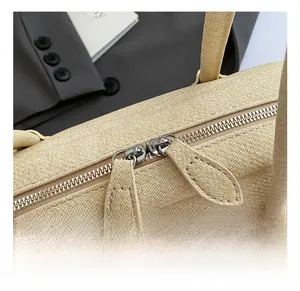 Détail de la double fermeture éclair argentée sur le sac Boston en cuir beige texturé