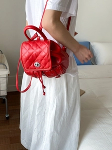 Elegant red quilted leather backpack with diamond stitching and silver turn-lock closure