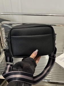 Black pebbled leather crossbody bag with wide striped strap and silver metal buckle