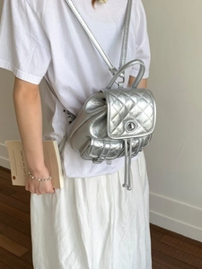 Chic silver quilted backpack for women featuring drawstring closure and metallic finish