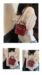 Detail of dark red vintage faux leather crossbody bag with metallic buckle and strap