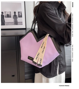 Détail du sac cabas plissé violet avec bordure en cuir noir et ruban décoratif chic