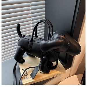 Detailansicht einer schwarzen Welpen-Handtasche mit glatter Lederstruktur und Reißverschluss