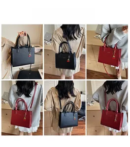Vielseitige mittelgroße Tote-Bags in Schwarz und Rot mit Kirsch-Anhänger in Tragevarianten