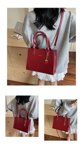 Detail der roten Handtasche mit Wellenkante und elegantem Kirsch-Anhänger Dekor