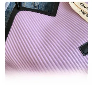 Détail macro du sac cabas matelassé violet avec rayures verticales et étiquette