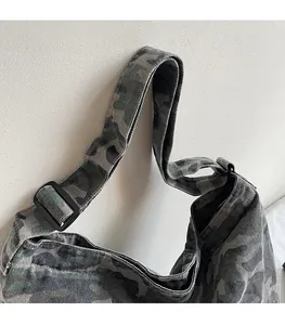 Close-up of adjustable strap buckle on camo canvas shoulder bag with durable fabric
